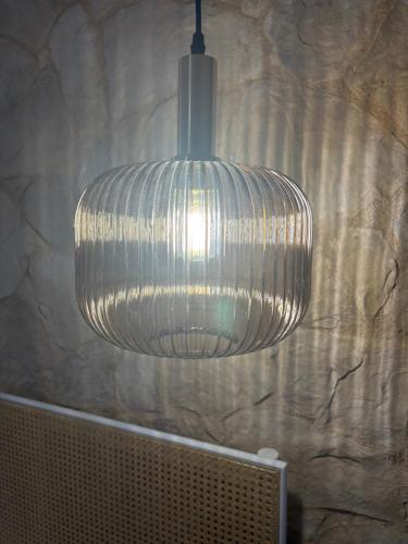 a large glass pendant light hanging from a wall at Llar Mediterrània in Alghero