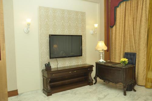 a living room with a flat screen tv on a wall at Royal Tulip Navi Mumbai in Navi Mumbai