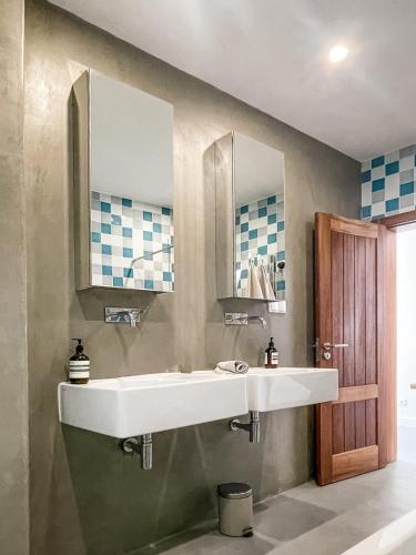 a bathroom with two sinks and two mirrors at Josy Lodge in Ferrel