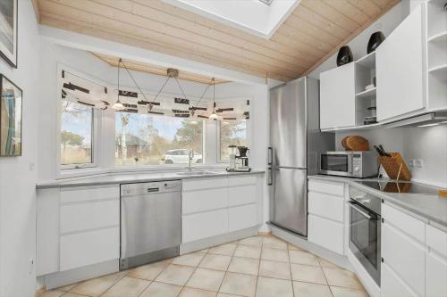 a kitchen with white cabinets and a large window at SL302-Slagelse-Dunhammervej-4 in Slagelse