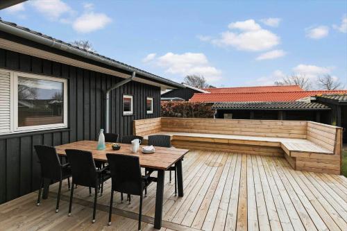 a patio with a wooden table and chairs on a deck at SL302-Slagelse-Dunhammervej-4 in Slagelse