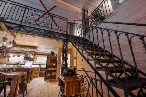 a staircase in a room with a kitchen and a dining room at Chalet Mikua, 6 p. spa, billard, Forêt & Nature in La Malbaie