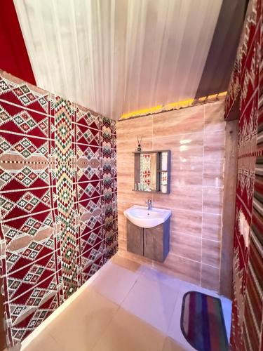 y baño con lavabo y azulejos rojos y blancos. en Fun Camp Wadi Rum, en Wadi Rum
