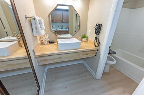 a bathroom with a sink and a mirror at Direct Ocean Front, The Pavilion, Pools, Boardwalk in Myrtle Beach