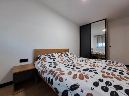 a bedroom with a large bed and a large mirror at Alpine Noir 2 in Bjelašnica