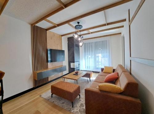 a living room with a couch and a table at Alpine Noir 2 in Bjelašnica