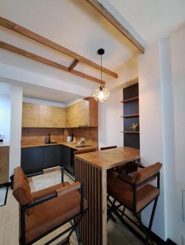 a kitchen with a wooden table and chairs at Alpine Noir 2 in Bjelašnica