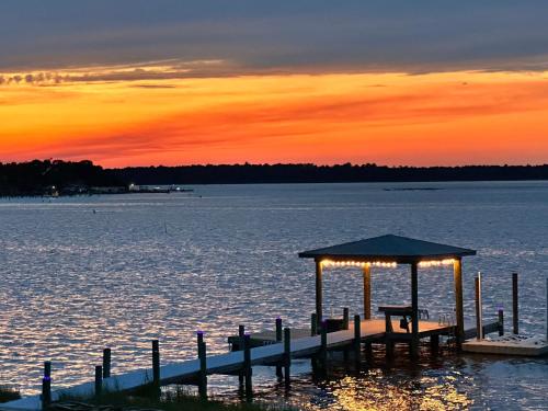a dock with a gazebo on the water at sunset at Relax,Fish,Grill,Chill! Pup,Kid Friendly Riverfront Paradise! Amenities,Gameroom in Sneads Ferry