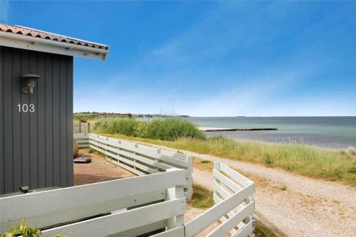 a house with a white fence next to the beach at SL190-Korsor-Svenstrup-Strandvej-103 in Korsør