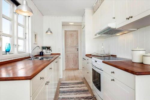 a kitchen with white cabinets and a wooden counter top at SL190-Korsor-Svenstrup-Strandvej-103 in Korsør
