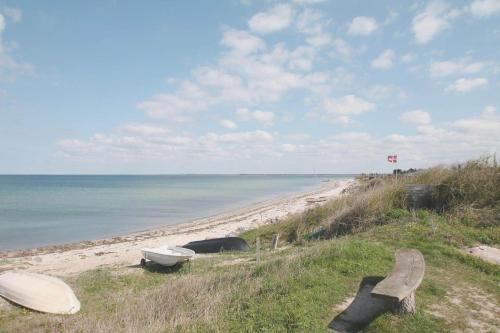 a beach with two benches and a boat on it at SL190-Korsor-Svenstrup-Strandvej-103 in Korsør