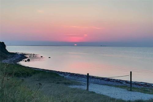 a sunset over a beach with the sun setting at SL190-Korsor-Svenstrup-Strandvej-103 in Korsør