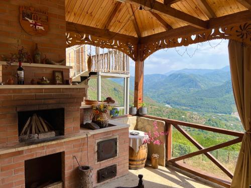 a fireplace in a room with a view of mountains at Gentry House in Ambrolauri