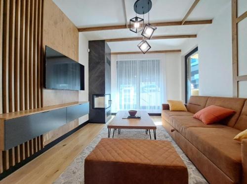 a living room with a couch and a table at Alpine Noir in Bjelašnica