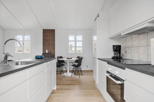 a white kitchen with a sink and a table at SL320-Slagelse-Kongsmarkvej-6 in Slagelse