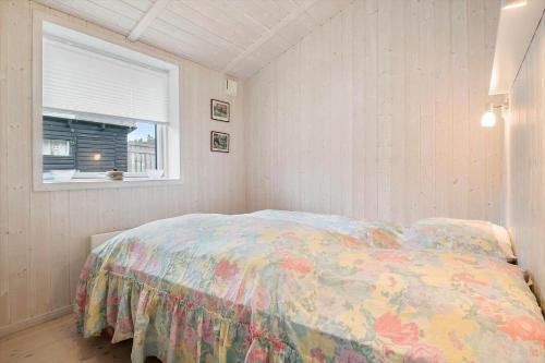 a bedroom with a bed with a colorful comforter and a window at SL328-Slagelse-Egebaekvej-21 in Slagelse