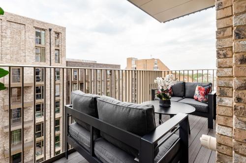 a balcony with a couch and a table at Perfect for London Bridge & St Kathrine Docks 2 Bed with AC in London