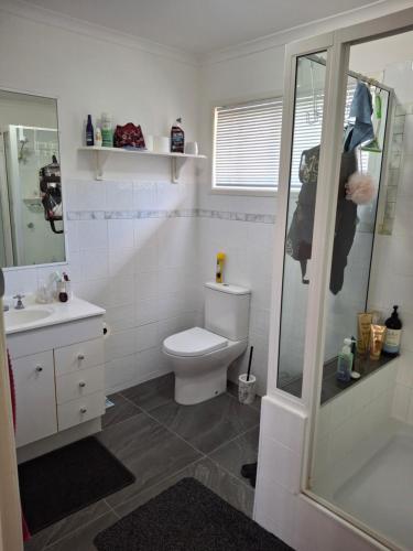 Un baño con inodoro, lavabo y ducha. en Sandi's Home, en Gladstone