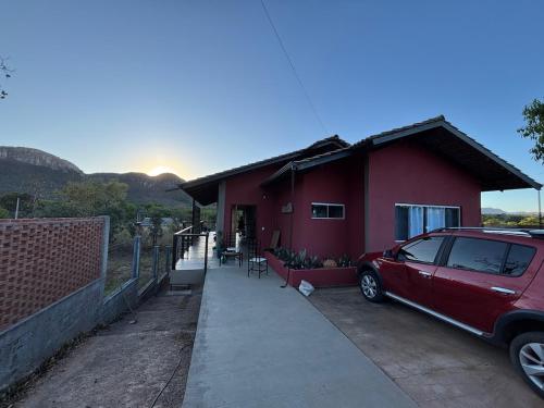 a red house with a car parked in front of it at Casa Cobogó in Cavalcante