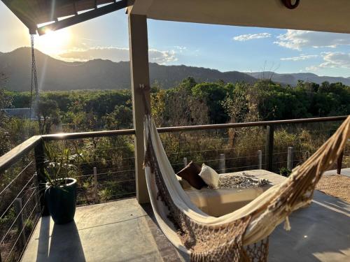 a hammock on a balcony with a view of the mountains at Casa Cobogó in Cavalcante