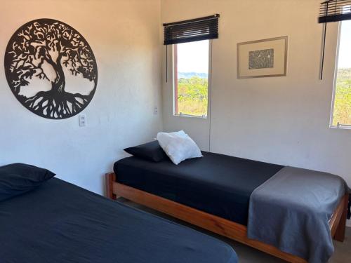 a bedroom with two beds and a tree picture on the wall at Casa Cobogó in Cavalcante