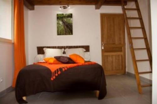 a bedroom with a bed with an orange comforter and a ladder at Chambres d’hôtes A Casa Di Marigaby in Barbaggio