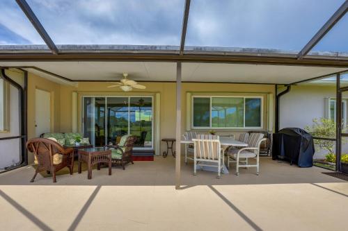 a covered patio with a table and chairs at Sunny Port St Lucie Home Lanai and Golf Course View in Port Saint Lucie