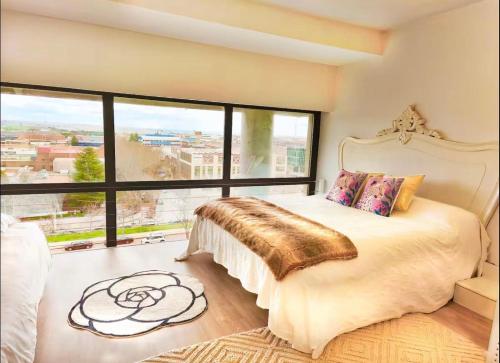 a bedroom with a large bed with a large window at Apartamentos Vacacionales Madrid España in Madrid