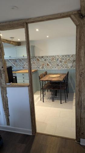 a kitchen and dining room with a wooden table at Magpie Cottage in Ledbury