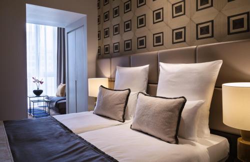 a bedroom with a bed with white sheets and pillows at The Posthouse Berlin Potsdamer Platz- Leonardo Limited Edition in Berlin