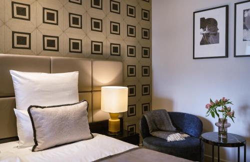 a bedroom with a bed and a chair at The Posthouse Berlin Potsdamer Platz- Leonardo Limited Edition in Berlin