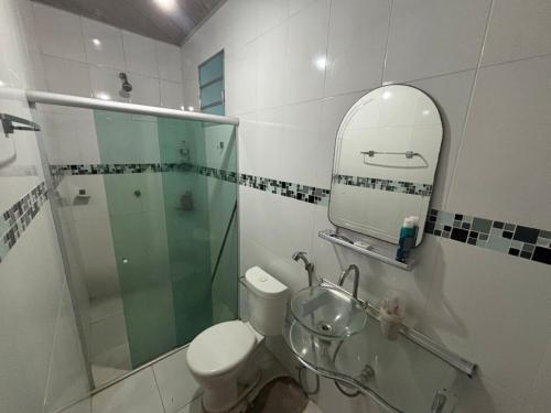 a bathroom with a toilet and a sink and a mirror at Casa para COP30 in Belém
