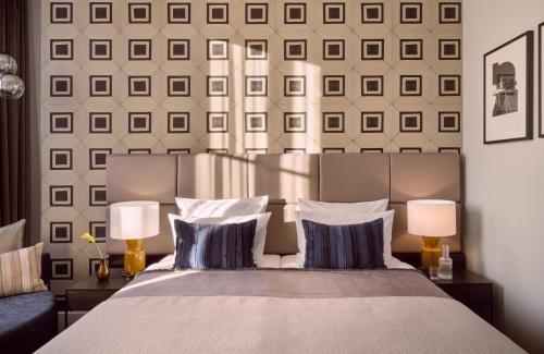 a bedroom with a bed with two lamps at The Posthouse Berlin Potsdamer Platz- Leonardo Limited Edition in Berlin