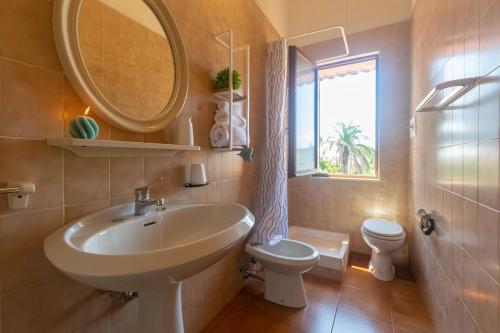 Quartu Sant'ElenaにあるCasa Pighettiの洗面台、トイレ、鏡のあるバスルーム
