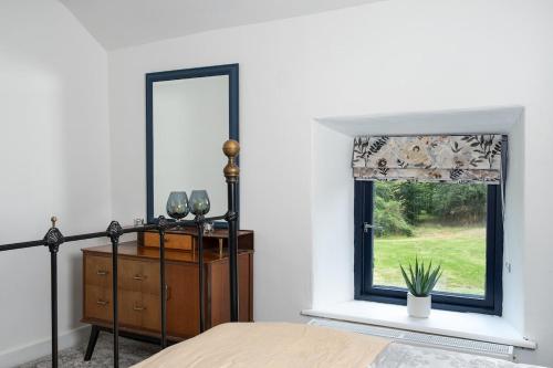 a bedroom with a mirror and a dresser and a window at Charming Country house Getaway in Edenderry