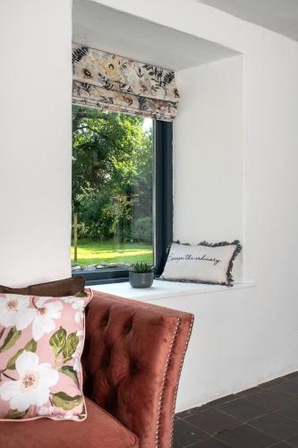 a living room with a couch and a window at Charming Country house Getaway in Edenderry