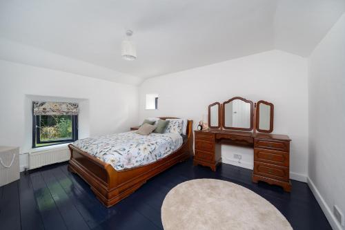 a bedroom with a bed and a dresser and a mirror at Charming Country house Getaway in Edenderry
