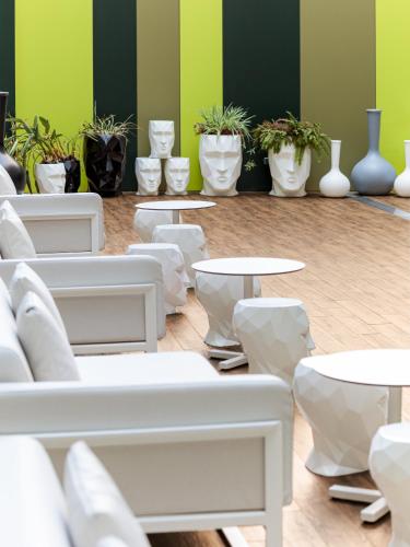 a room with white tables and potted plants at Room Mate Pau, Barcelona in Barcelona