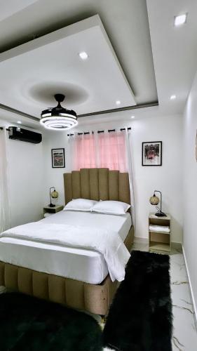 une chambre avec un grand lit blanc et une fenêtre dans l'établissement casa con piscina cerca de la playa Caleta 8 mnt de casa de campo Residencial los garcia la romana, à La Romana