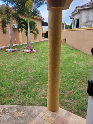 a pole in a yard with palm trees at Tiny home- likle but wi tallawah in Mandeville
