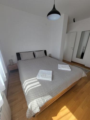 ベオグラードにあるPark residence Apartman 2, Mirijevo, Serbiaのベッドとタオル2枚のある寝室