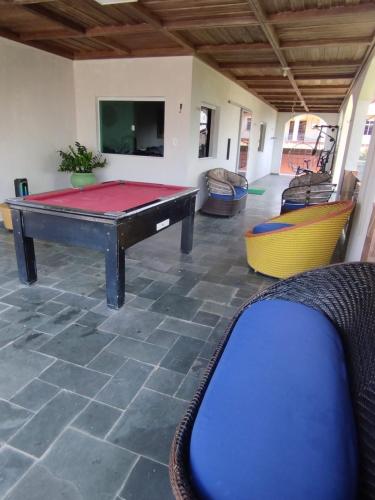 a pool table in the middle of a room with chairs at Casa com Piscina Grande em Salinas in Salinópolis
