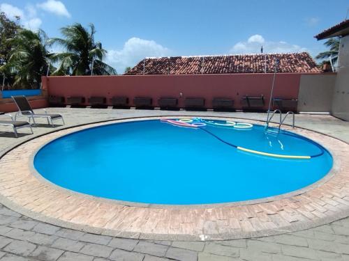 a large blue swimming pool with chairs around it at Casa com Piscina Grande em Salinas in Salinópolis