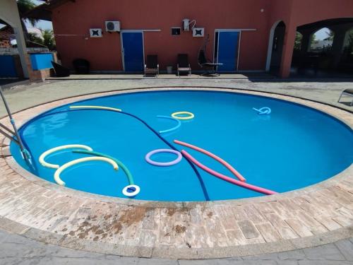 a blue swimming pool in front of a red building at Casa com Piscina Grande em Salinas in Salinópolis