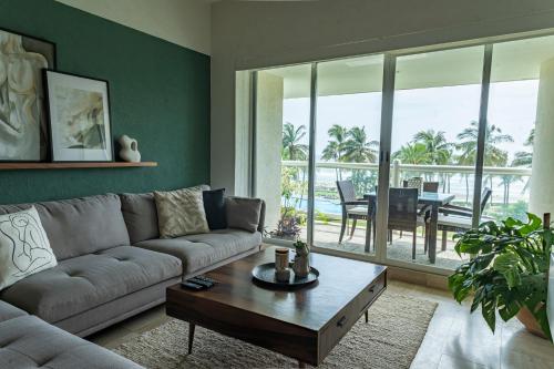 a living room with a couch and a table at Departamento Mayan Island - A pie de playa y con albercas in Acapulco
