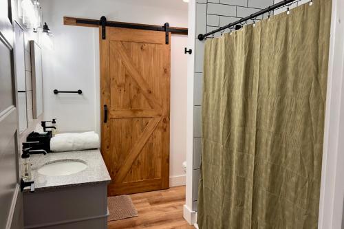 a bathroom with a shower with a wooden door at Private Pickleball Court, Gym, Arcade, & Hot Tub! in Dahlonega