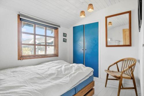 a bedroom with a bed and a chair and a window at SL243-Skaelskor-Hybenvej-30 in Skælskør