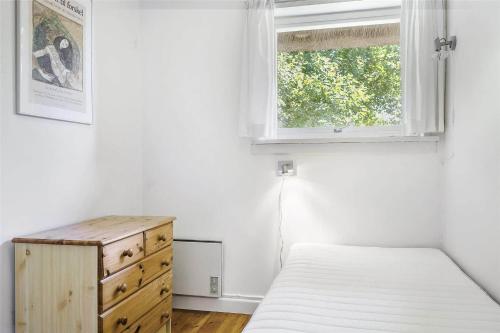 a bedroom with a bed and a dresser and a window at K19015-Kalundborg-Klintegardsvej-45 in Kalundborg