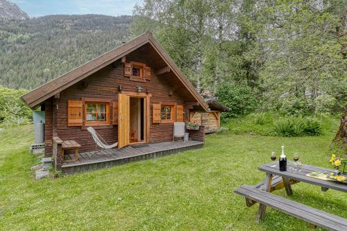 Una cabaña de troncos en un campo con una mesa de picnic. en Mazot Mer de Glace - Happy Rentals, en Chamonix-Mont-Blanc