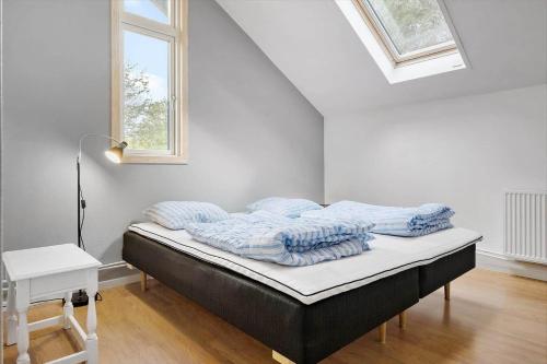 a bed in a white room with a window at K19007-Kalundborg-Strandskraenten-11 in Kalundborg